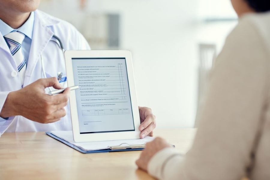 Profissional mostrando uma prescrição eletrônica para o paciente na Efetiva Telessaúde